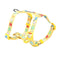 Yellow dog harness with colorful cartoon designs on a white background