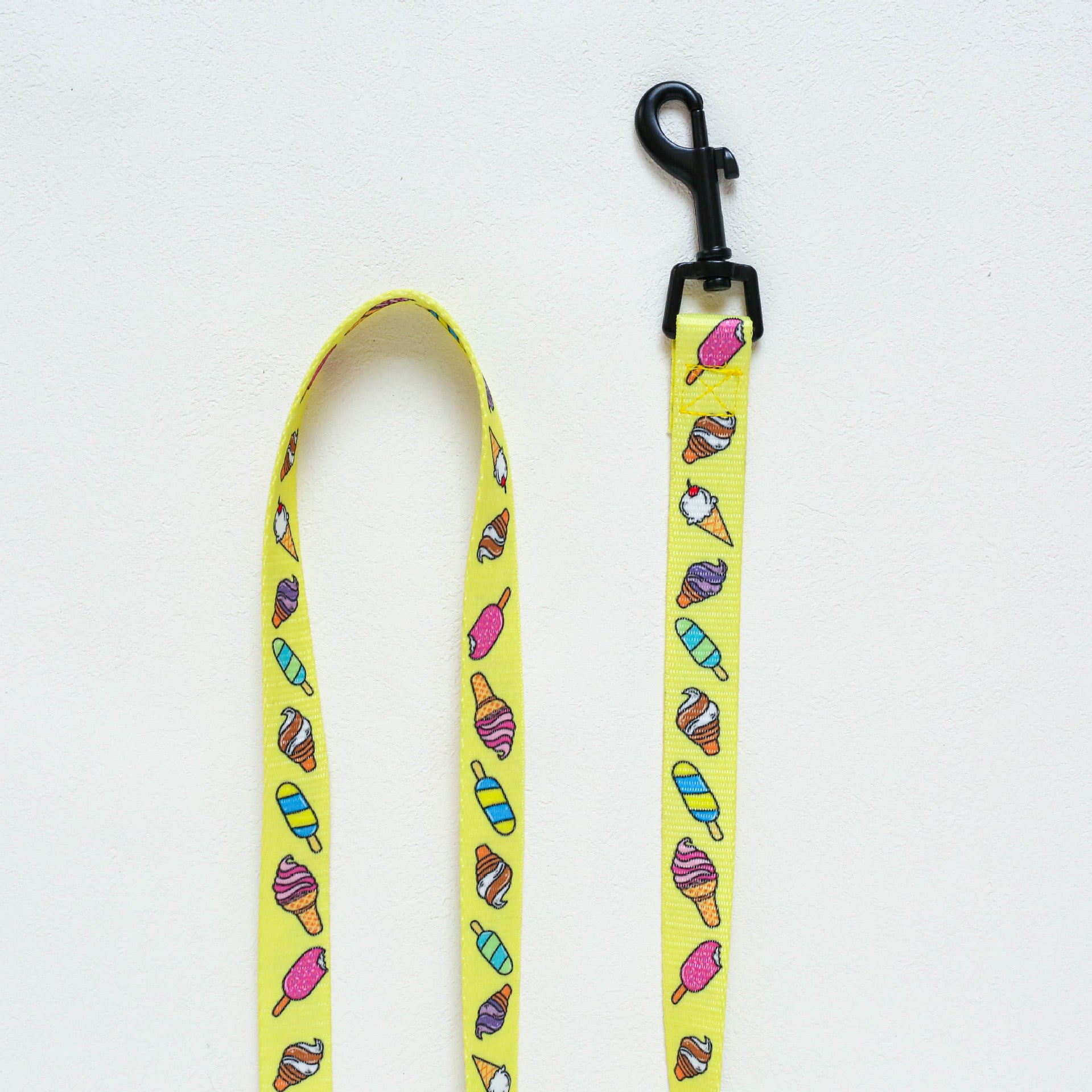 Yellow dog leash with ice cream cone pattern on a white background