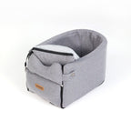 A portable car seat bed for small dogs and cats, made from canvas and suede with a plush lining, displayed in a creamy white color.