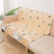 Beige sofa with a cartoon cat patterned throw blanket in a living room setting.