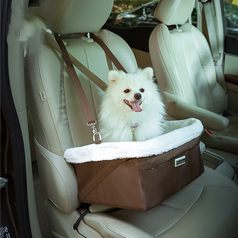 White dog in a brown pet seat in a car