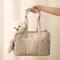 Beige tote bag with a teddy bear and rolled-up mat on a light background