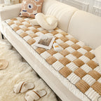 Sofa with a textured brown and beige cushion, plush rug, and decorative pillows.