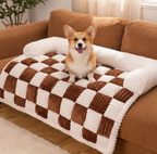 Corgi dog on a checkered pet bed in a cozy living room.
